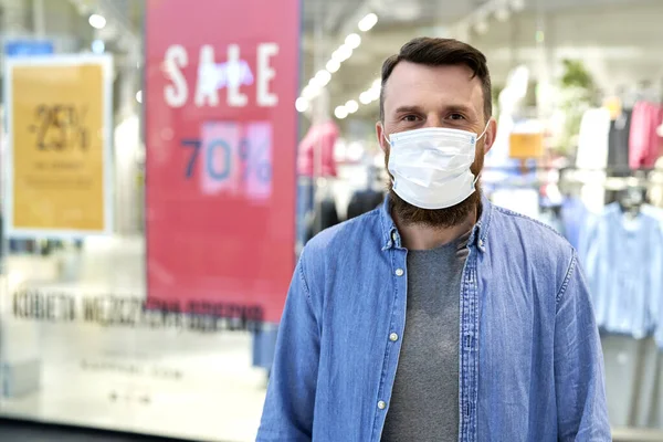 Front view of man in protective face mask in shopping mall