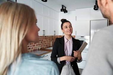 Emlakçı bir çifte yeni bir daire gösteriyor.                               