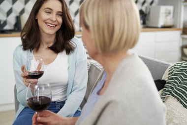 İki kuşak kadın evde şarap içiyor.