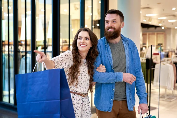 ショッピング中に笑顔のカップルがショッピングモールで — ストック写真