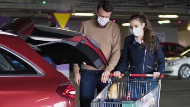 Vídeo Casal Embalando Mantimentos Carro Durante Uma Pandemia Tiro Com — Vídeo de Stock