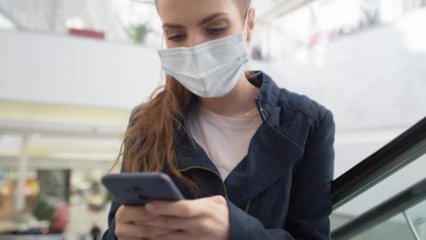 Vídeo Mulher Máscara Médica Usando Smartphone Escada Rolante Tiro Com — Vídeo de Stock