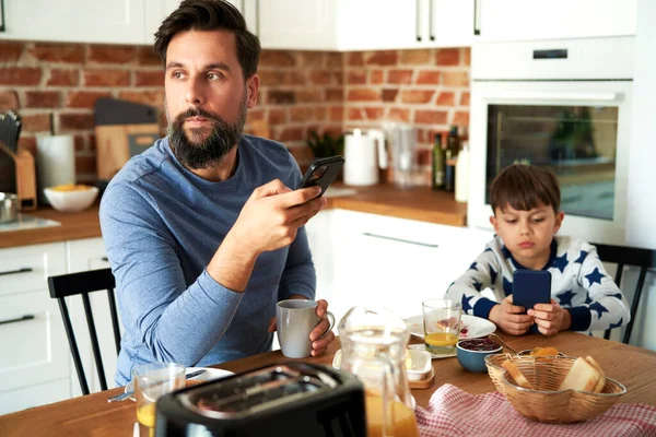Otec Syn Při Snídani Pomocí Mobilního Telefonu — Stock fotografie