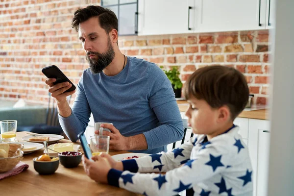 Enfocado Padre Hijo Con Teléfono Móvil Durante Desayuno —  Fotos de Stock