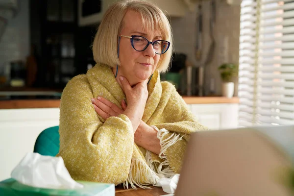病気の女性は自宅でラップトップを使用してオンラインで医師に相談します — ストック写真