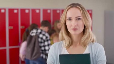 Okul koridorunda duran okul öğretmeninin video portresi. 8K 'da kırmızı helyum kamerayla çekildi..