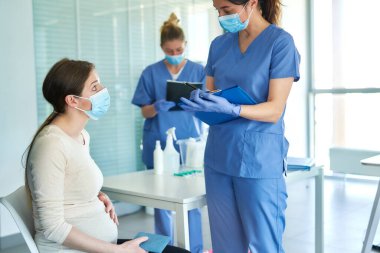 Hamile kadın aşıdan önce tıbbi bir görüşme sırasında                               