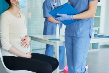 Aşıdan önce koruyucu maske takmış hamile kadınların fotoğraflarını çek.                               