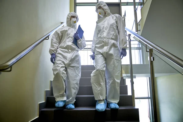 Dva Lidé Ochranném Obleku Jdou Dolů Schodech — Stock fotografie