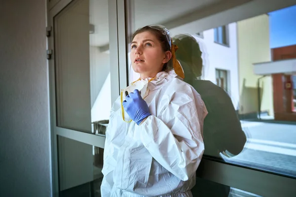 Zmęczona Kobieta Kombinezonie Ochronnym Zdejmuje Maskę Ochronną — Zdjęcie stockowe