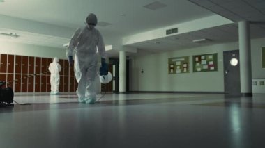 Temizlik işçilerinin bina koridorunu dezenfekte edişinin statik videosu. 8K 'da kırmızı helyum kamerayla çekildi..