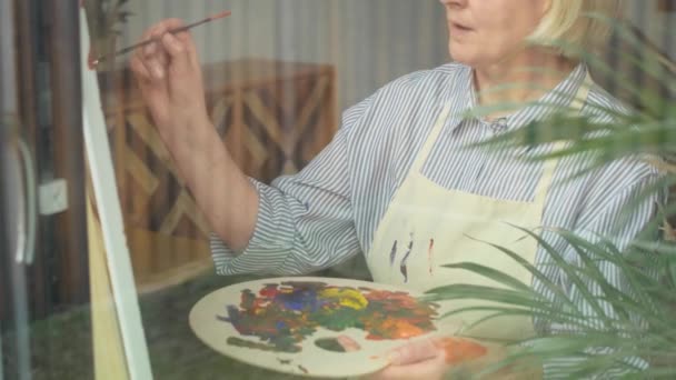 彼女の自宅でシニア女性アーティストの絵画のビデオ 8Kでレッドヘリウムカメラで撮影 — ストック動画