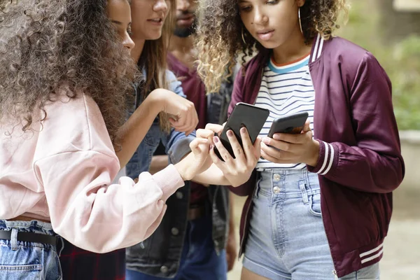Groep Jongeren Die Naar Mobiele Telefoons Staren — Stockfoto