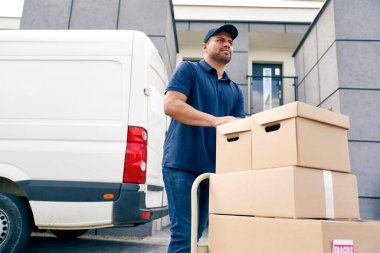 El arabasında paket taşıyan kuryenin alt görüntüsü.
