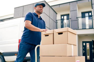 Kuryenin el arabasındaki paketlerle gidişinin alt görüntüsü