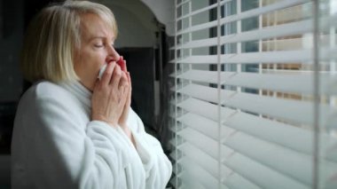 Camdan dışarı bakan hasta yaşlı kadının videosu. 8K 'da kırmızı helyum kamerayla çekildi.