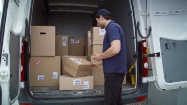 Bagajdaki paketleri kontrol eden kurye videosu takip ediliyor. 8K 'da kırmızı helyum kamerayla çekildi..