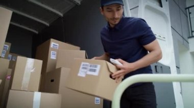 Kurye kontrol ve boşaltma paketini el arabasına yükleme videosu. 8K 'da kırmızı helyum kamerayla çekildi..