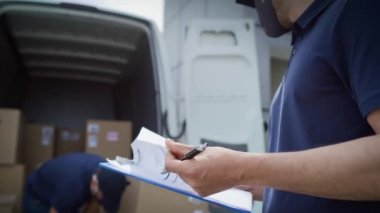 Paketleri boşaltan ve belgeleri kontrol eden kuryelerin videosu. 8K 'da kırmızı helyum kamerayla çekildi..