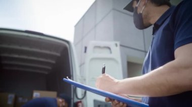 Belgeleri kontrol eden ve paketleri boşaltan kuryelerin videosu. 8K 'da kırmızı helyum kamerayla çekildi..