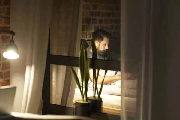 窓に映る夜仕事をする男 — ストック写真