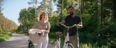 Ormanda bisiklet süren bir çiftin videosu. 8K 'da kırmızı helyum kamerayla çekildi..