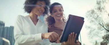 Açık havada dijital tabletli iki iş kadınının videosu. 8K 'da kırmızı helyum kamerayla çekildi..