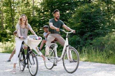 Ormanda bisiklet süren eğlenceli bir aile.                               