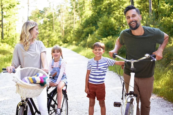 森林里骑自行车的快乐家庭的画像 — 图库照片