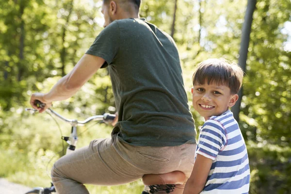 自然の中で父と一緒に自転車に乗る少年の肖像画 — ストック写真
