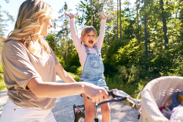 森の中で母親と一緒に幸せな女の子サイクリング — ストック写真