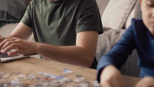 Video Von Langeweile Junge Löst Puzzle Während Vater Arbeitet Aufnahme — Stockvideo