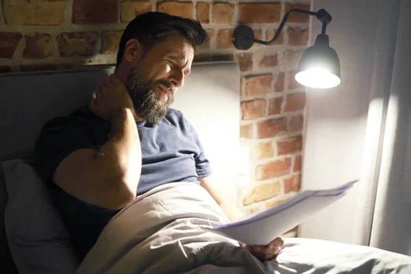 Evrakları Olan Yorgun Bir Adam Geç Saatlere Kadar Yatakta Çalışıyor — Stok fotoğraf