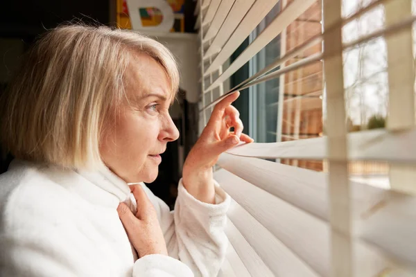 Zijaanzicht Van Oudere Vrouw Die Uit Het Raam Kijkt — Stockfoto