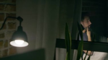 Akşamları evdeki bilgisayarında çalışan bir adamın videosu. 8K 'da kırmızı helyum kamerayla çekildi..