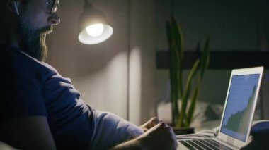 Yatakta çalışırken yorgun bir adamın videosu. 8K 'da kırmızı helyum kamerayla çekildi..