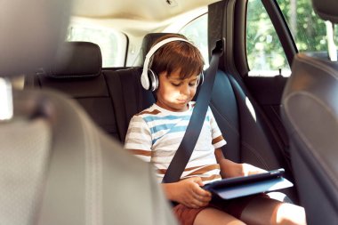 Araba sürerken dijital tabletli çocuk                               