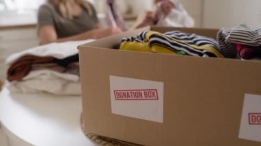 Anne ve kızının bağış için kıyafet sıralamasını gösteren bir video. 8K 'da kırmızı helyum kamerayla çekildi.