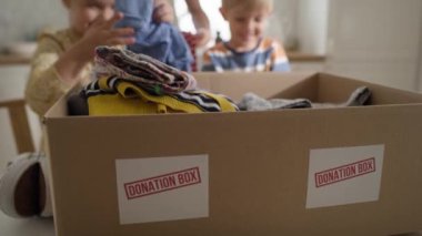 Çocukların bağış için kıyafet sıralama videolarını kapat. 8K 'da kırmızı helyum kamerayla çekildi.