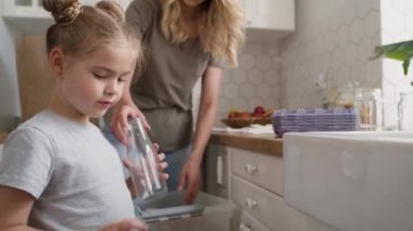 Anne ve kızının evde geri dönüşüm malzemelerini ayırdığı bir video. 8K 'da kırmızı helyum kamerayla çekildi.