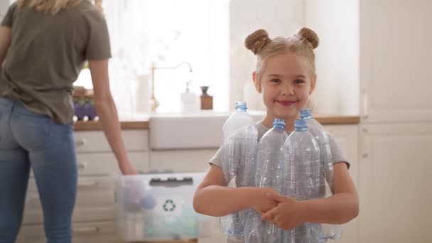 Πορτρέτο Βίντεο Χαμογελαστό Κορίτσι Κρατώντας Πλαστικά Μπουκάλια Στην Κουζίνα Πυροβολήθηκε — Αρχείο Βίντεο