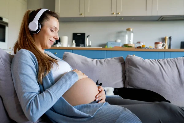 Mujer Embarazada Con Auriculares Tumbados Sofá —  Fotos de Stock