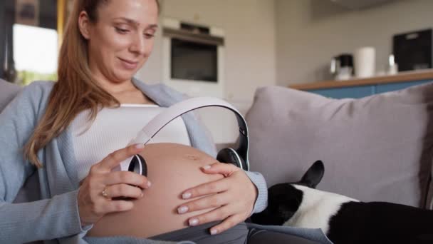 Donna Incinta Che Tiene Cuffie Sulla Pancia Girato Con Telecamera — Video Stock