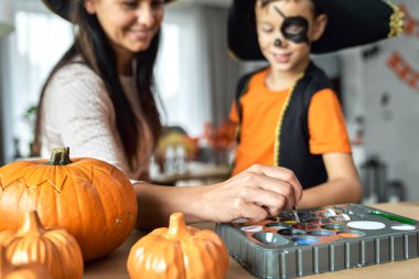 Anne oğlunu Cadılar Bayramı partisine hazırlıyor.  