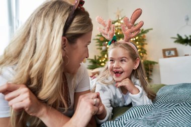 Küçük kız Noel sabahını annesiyle geçiriyor.