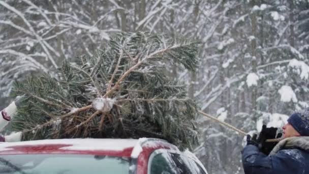 Uomo Con Padre Anziano Attacca Albero Natale Alla Macchina — Video Stock