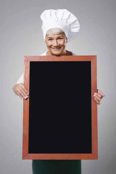 Experienced female chef with blackboard — Stock Photo, Image