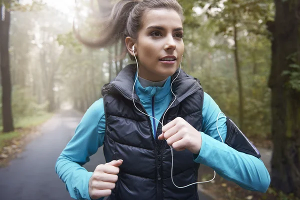 Mujer escuchando música mientras corre — Foto de Stock