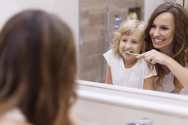 Mother teaches daughter to brush teeth — Stock Photo, Image