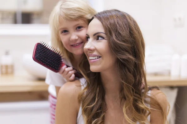 Mädchen macht Frisur für ihre Mutter — Stockfoto